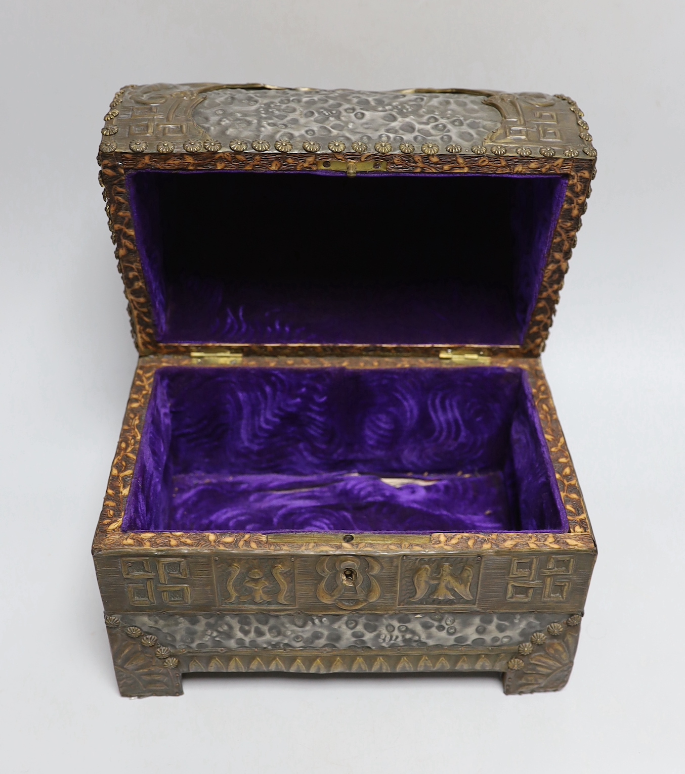 An early 20th century hammered pewter and brass neo-gothic casket, with poker work and velvet interior, 22cm high